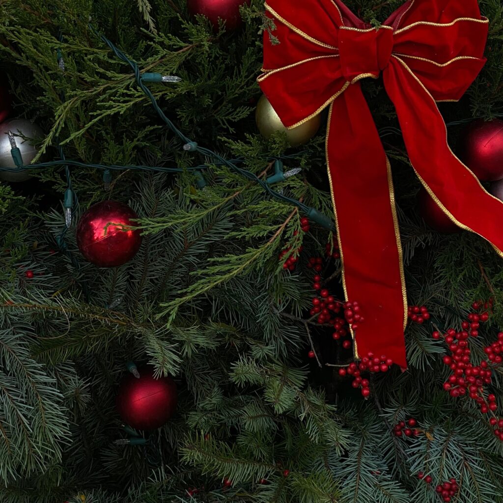 A Christmas tree with red berries picks.