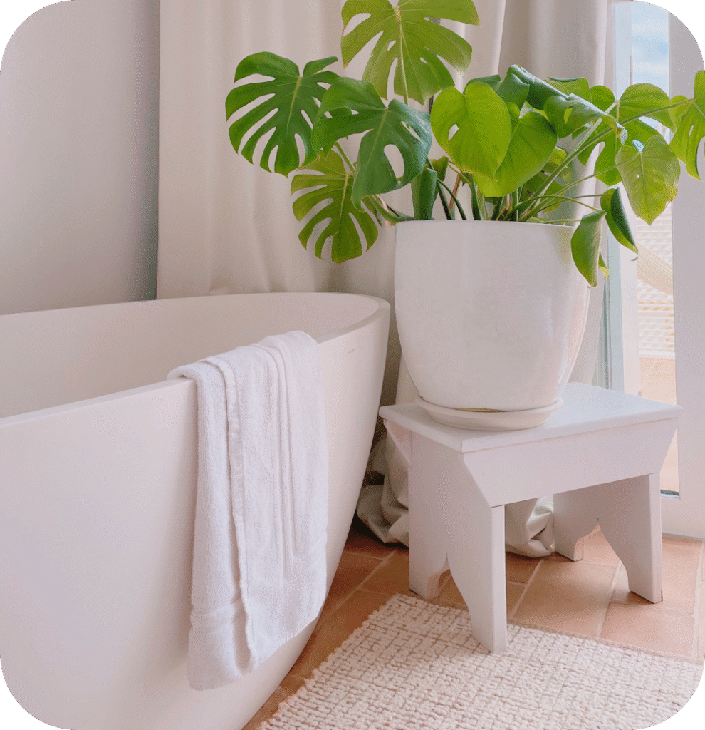 A white bathroom with a beige bathroom rug.