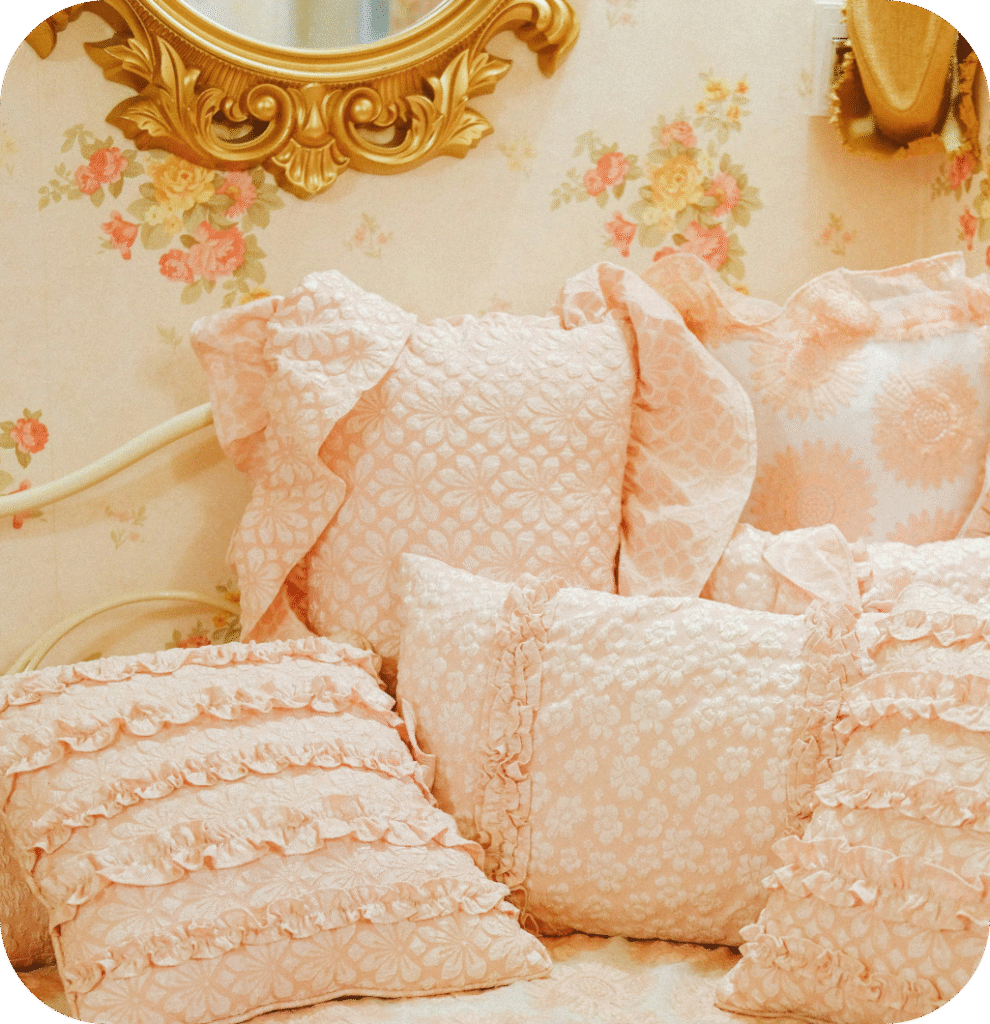 Pink pillows and an antique gold mirror.