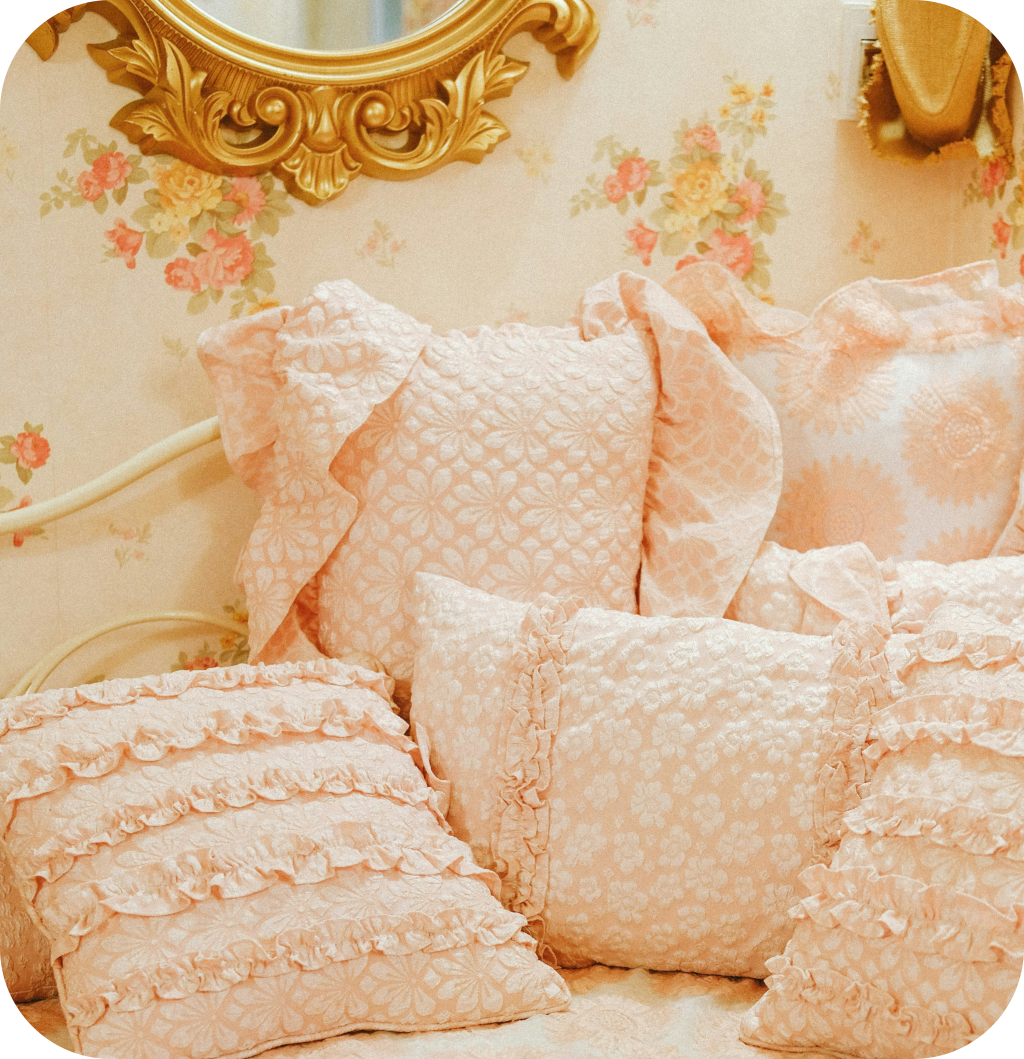 Pink pillows and an antique gold mirror.