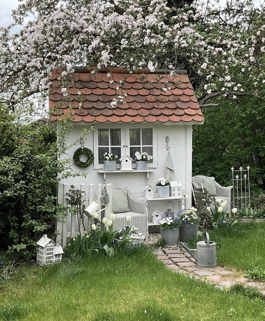 A little house with galvanized planters.