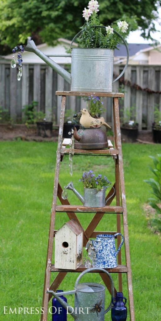 A rustic ladder shelf with galvanized watering pots.